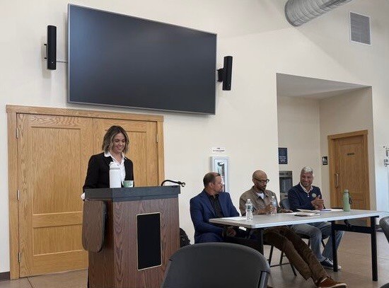 Allie Hager moderating a panel discussion from the podium